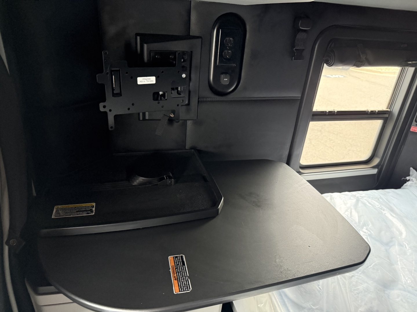 Kenworth T680 sleeper cab interior featuring a fold-out desk or table surface and window view.