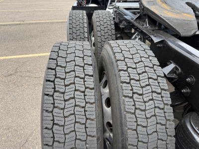 Kenworth T680 truck rear dual tires and chassis frame, tread pattern visible on tires, components and wheel hubs in view.