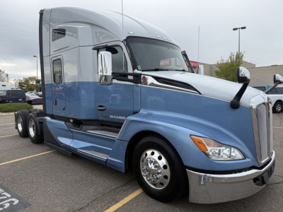 Kenworth T680 semi truck in blue and gray, side view showing cab and sleeper, chrome front bumper and wheels,VIN label not visible.