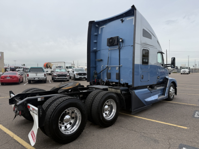 Kenworth T680 tractor with blue sleeper cab and rear wheels, side view showing fifth wheel and mud flaps.