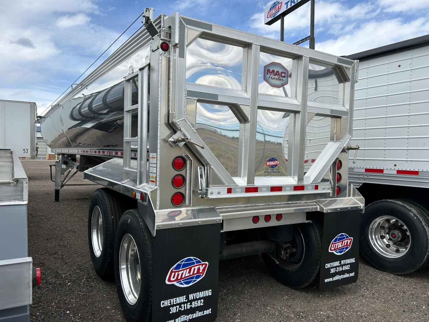 Mac Macsimiser frameless aluminum end dump trailer showing rear view with Mac logo, dual axles, and reflective markings.