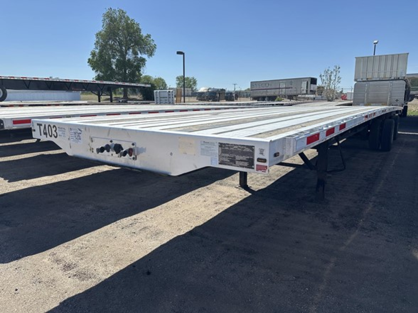 Flatbed trailer showing low-profile aluminum deck with side reflectors and rear wheels in view, 2020 Transcraft Cal Legal Spread Air Combo Flatbed, VIN 150120349472, stock UE11491.