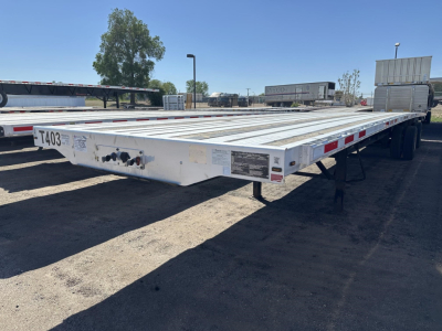 Transcraft combo flatbed trailer in-view showing long aluminum deck with reflective safety tape and rear wheels; front left shows license plate-like plate with numbers.