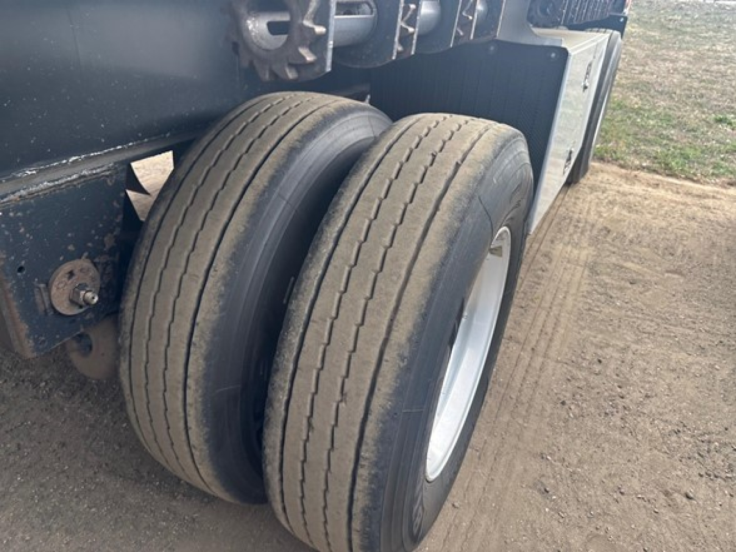 Dual rear trailer tires on a 2022 Utility 4000 Ae flatbed trailer showing two black tires with silver rims.