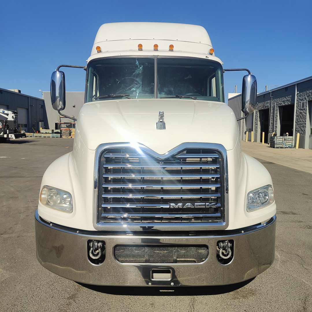 Truck front view of white 2016 Mack CXU613 sleeper cab showing chrome grille and bumper.