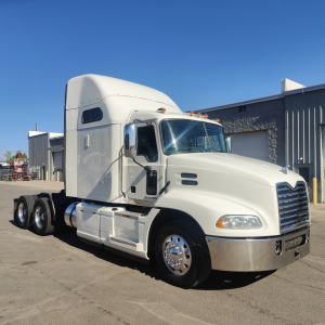 White 2016 Mack CXU613 conventional sleeper truck viewed from side-front angle show chrome bumper, twin rear axles, and sleeper cab