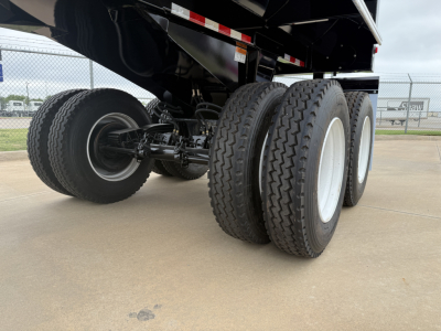Armor Lite SHD32/48 trailer axles and wheels undercarriage view showing dual rear tandems and raised dump bed.