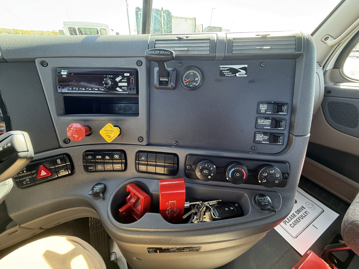 Dashboard of a Freightliner CA11364DC daycab showing controls, ignition, red engine brake switch, and key ring.