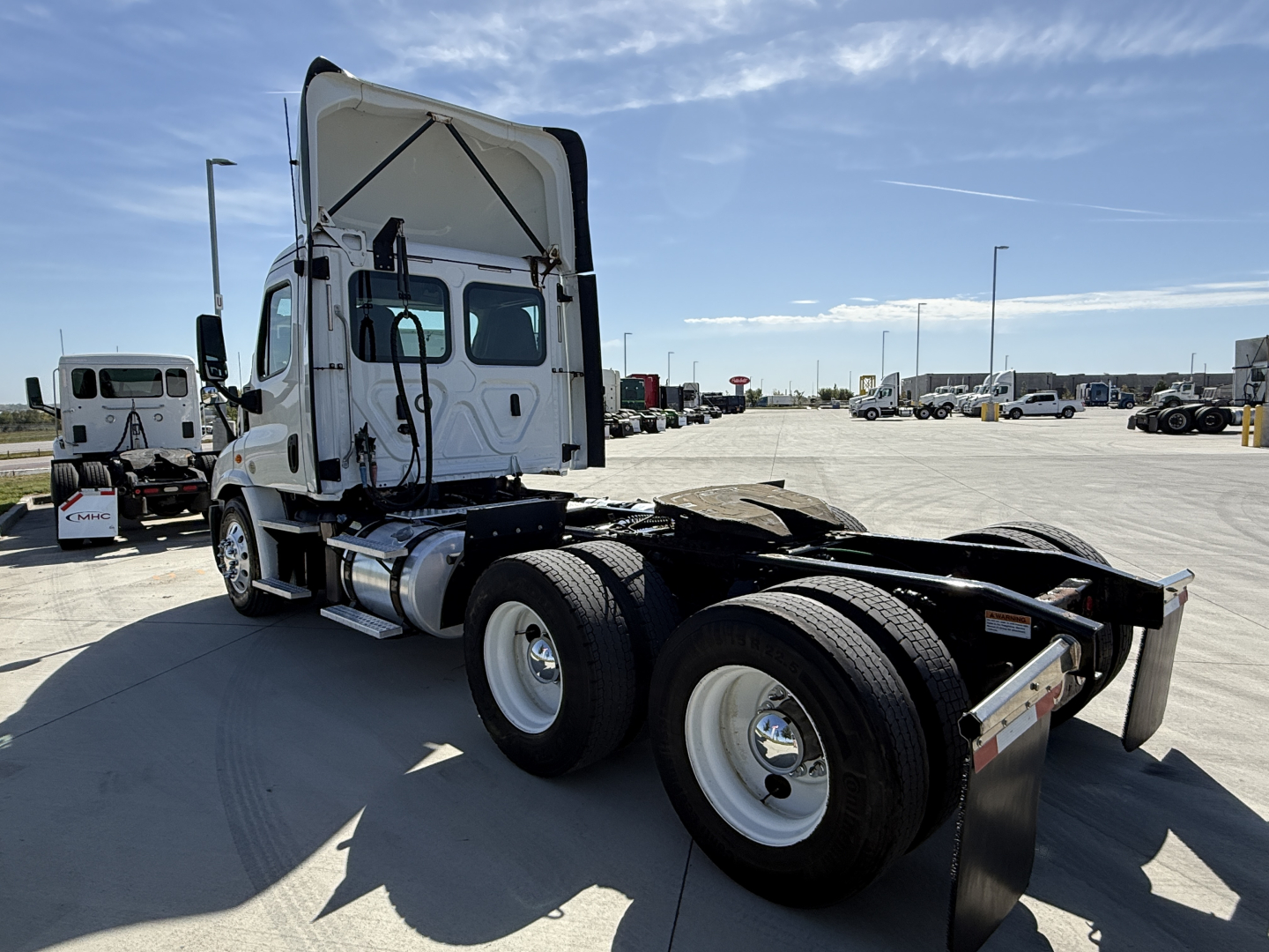 Freightliner CA11364DC truck tractor rear view showing wheels and fifth wheel, cab with raised sleeper, white exterior, GVW/axle area not legible.