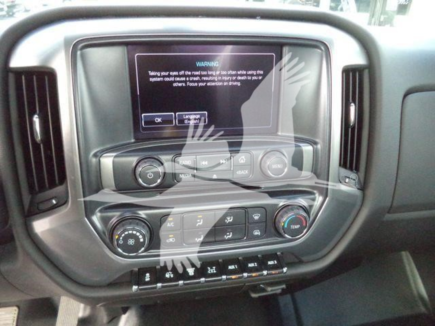 Chevrolet Silverado 6500HD dash center console showing touchscreen display with warning message and multiple control knobs and climate buttons.