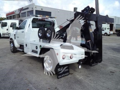 Truck-mounted tow crane on a 2023 Chevrolet Silverado 6500HD in-service with winch equipment and spare tires visible in the cab area.
