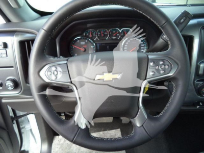 Steering wheel and dashboard of a 2023 Chevrolet Silverado 6500HD interior showing gauges and steering controls.