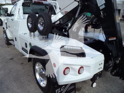 Truck bed with tow winch and dual rear wheels, white Chevrolet Silverado 6500HD, with hydraulic crane and accessories visible