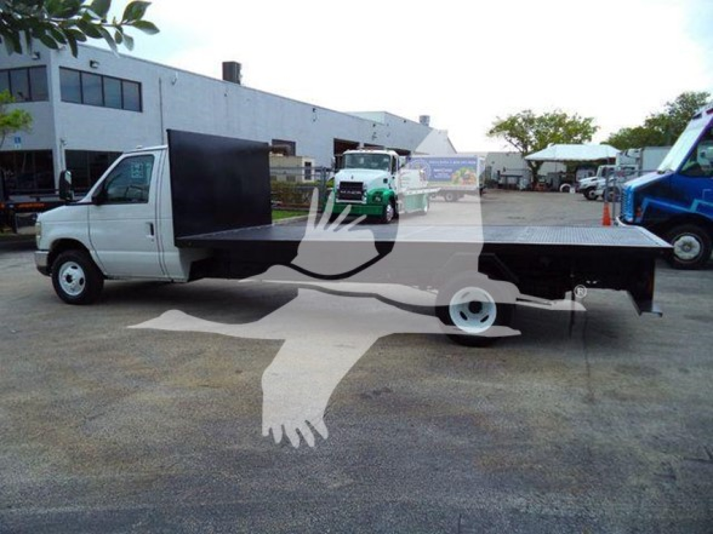 Flatbed tow truck on a paved lot with white cab and black flatbed, 2011 Ford E450, VIN 1FDXE4FSXBDA07531, stock T07531.