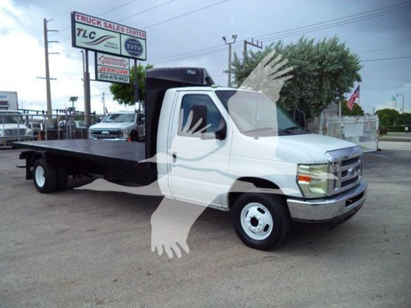 Ford E-450 flatbed truck in-service view showing flatbed bed with cab and two front wheels, stock number T07531 seen in dealership lot.
