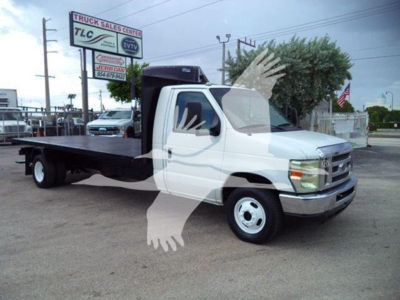 Ford E-450 flatbed truck in-service view showing flatbed bed with cab and two front wheels, stock number T07531 seen in dealership lot.