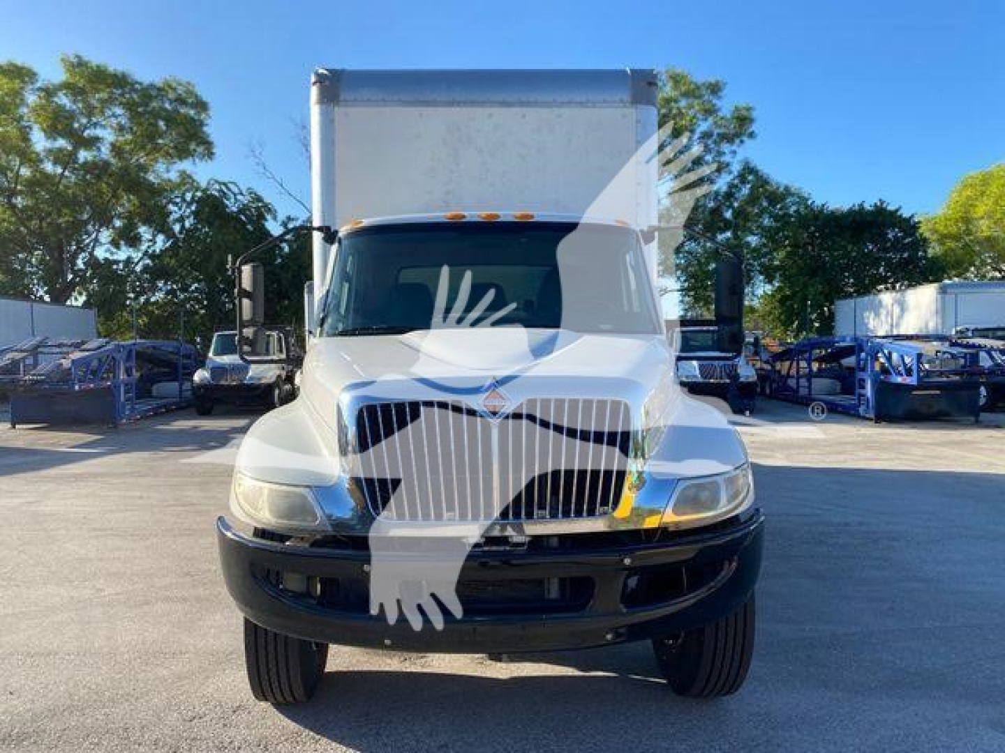 Front view of a white 2020 International MV box truck showing the grille, headlights, and cargo box; windshield wipers and side mirrors visible.
