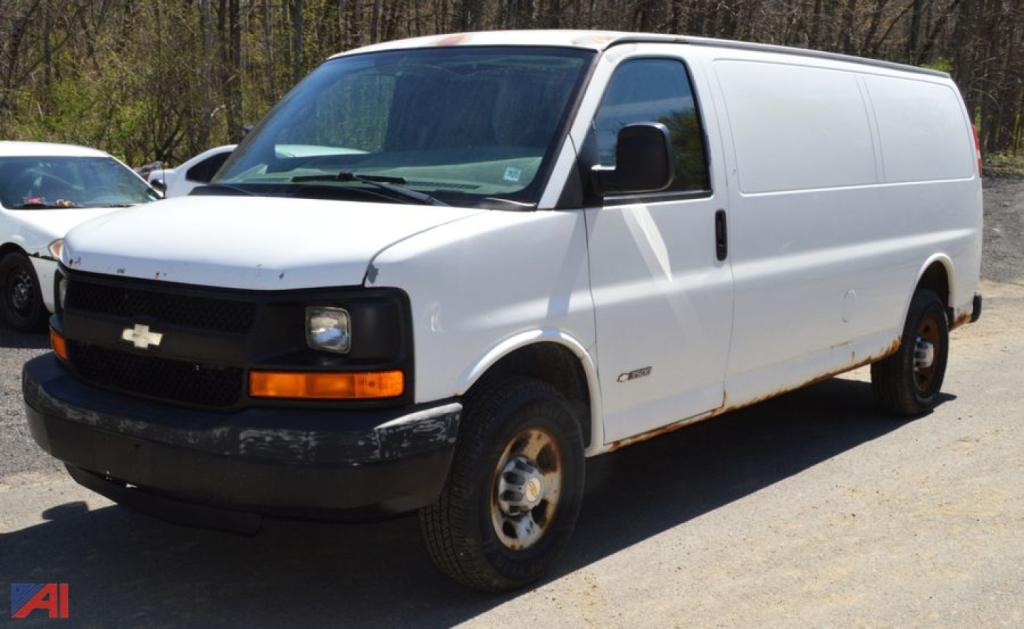 White 2004 Chevrolet Express 3500 cargo van in a parking lot, side and front views visible; Chevrolet bowtie grille emblem, black bumper, blank side panels, no windows on cargo area.