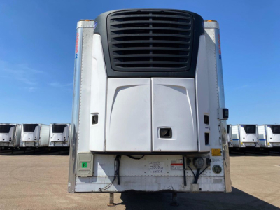 Front view of a 2018 Utility reefer trailer showing the nose with large black grille and shut panels, white exterior with side doors, and surrounding yard of refrigerated trailers.