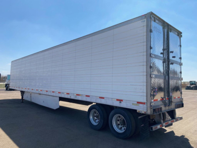 Utility reefer trailer in side view with tandem axles and rear doors. No legible branding visible; text not readable on image.