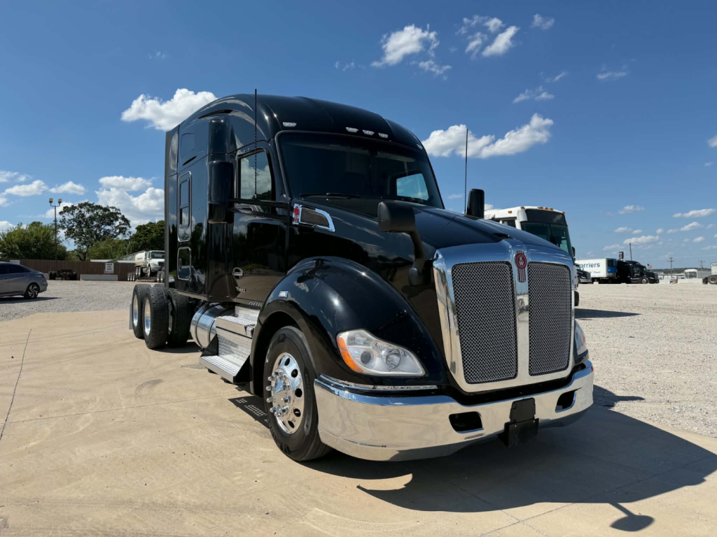 Kenworth T680 tractor in view showing front grille and bumper with chrome accents, black paint, and KW emblem