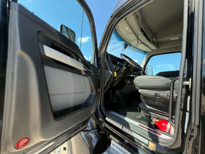 Kenworth T680 truck interior and open driver door showing dashboard, steering wheel, and seat; cab entry with exterior door panel and step