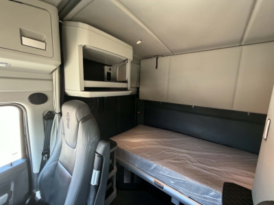 Kenworth T680 sleeper cab interior showing bunk bed and overhead storage compartment.
