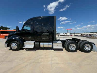 Kenworth T680 sleeper cab tractor in black with chrome fuel tanks and side steps, side view showing tractor without trailer.