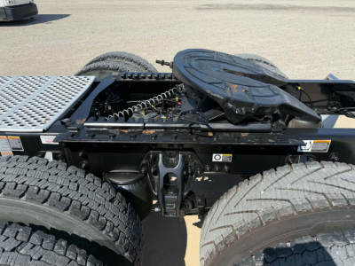 Kenworth T680 tractor cab chassis showing fifth wheel and rear axle area with spare tire mount and drivetrain components visible.