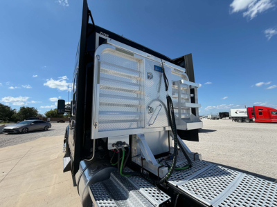 Kenworth T680 truck rear view showing tail area with chrome fuel lines and silver diamond plate steps.