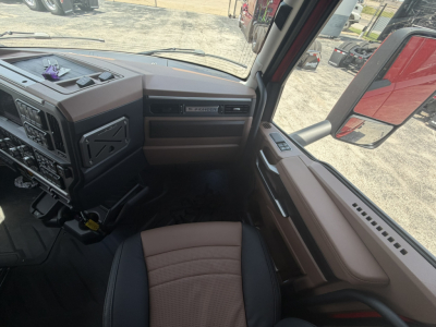 Mack truck cab interior showing dashboard controls and passenger seat area.
