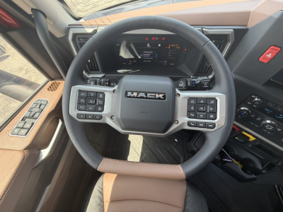 Mack PR64T76H steering wheel and dashboard with numerous control buttons visible in a truck cab interior.