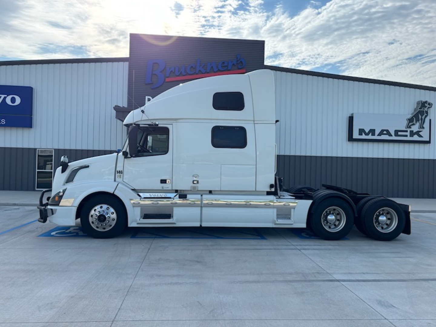 Volvo VNL780 convention sleeper tractor in side view showing cab and tandem rear, white paint, bunk window, and chrome steps.