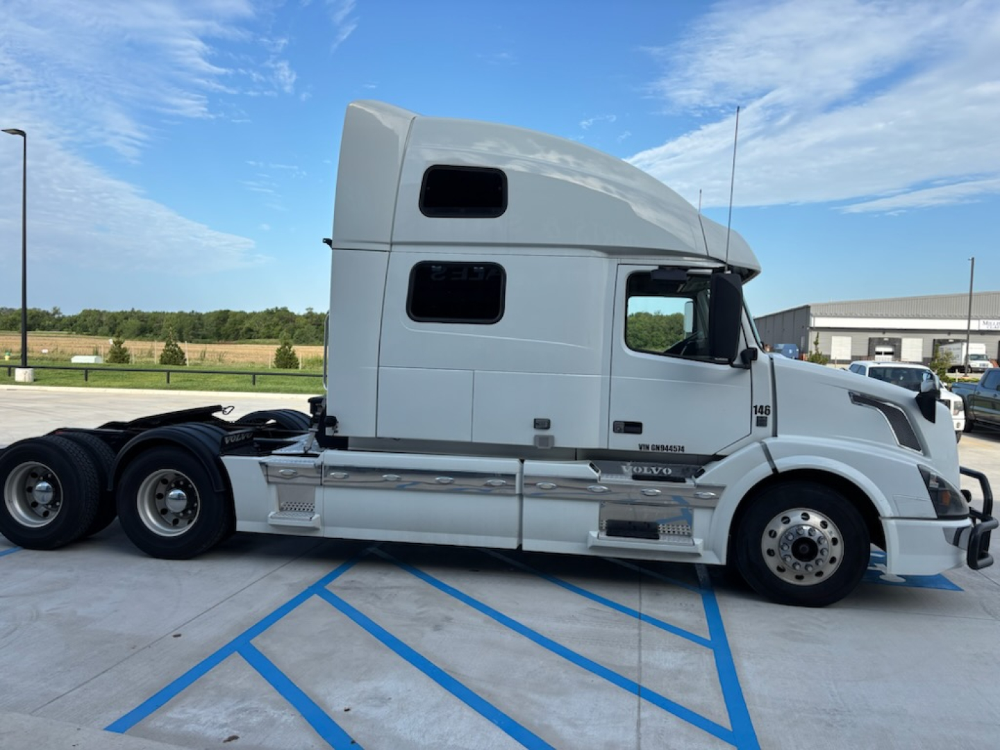 Side view of a white Volvo VNL780 sleeper cab tractor showing two stacked windows, chrome fuel tanks, side steps, rear wheels, and a prominent hood.