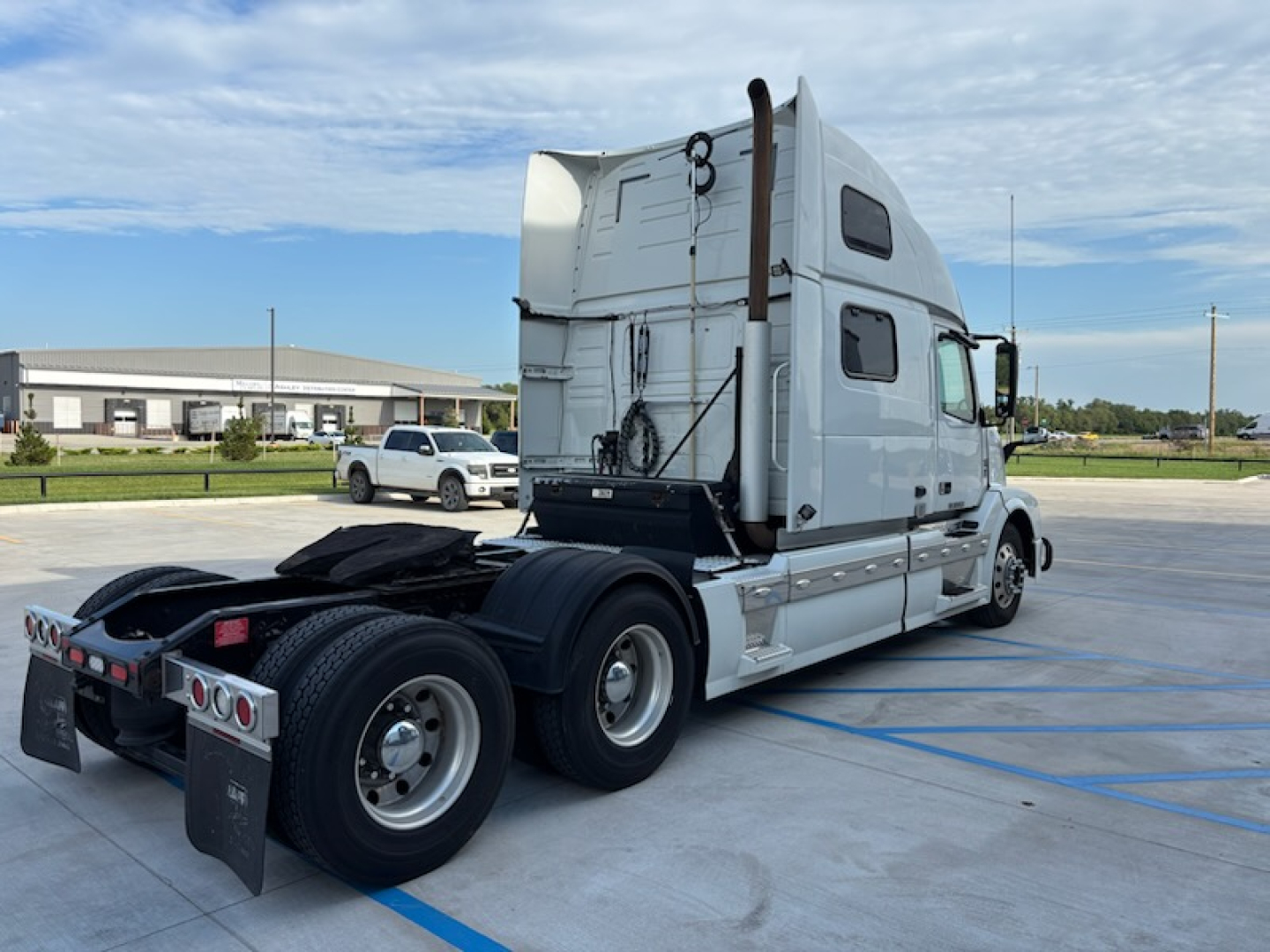 Tractor-trailer truck rear and side view with sleeper cab and dual rear axles. Visible text on the truck includes no legible branding in this view. VIN/title and stock numbers not shown on the vehicle itself.