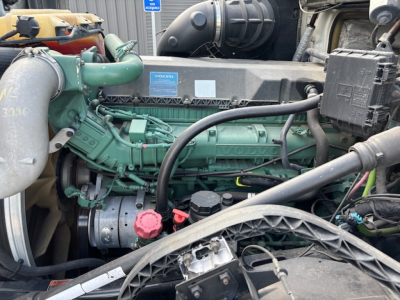 Volvo VNL780 engine bay showing turbocharger, green engine block, hoses, and Volvo badge on cover plate.