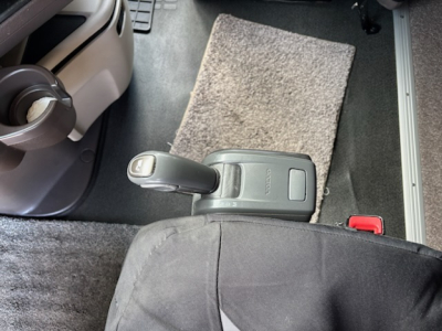 Cab interior of a 2016 Volvo VNL780 showing center console with gear shifter, cup holder, and floor mat.