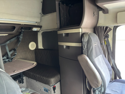 Volvo VNL780 sleeper cab interior showing seating, storage compartments, and cabin area.
