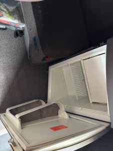 Volvo VNL780 truck sleeper cab interior showing open cooler/fridge compartment and storage area.
