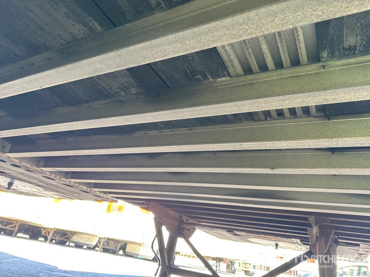 Trailer underside view with metal support beams and frame; no legible labels visible.