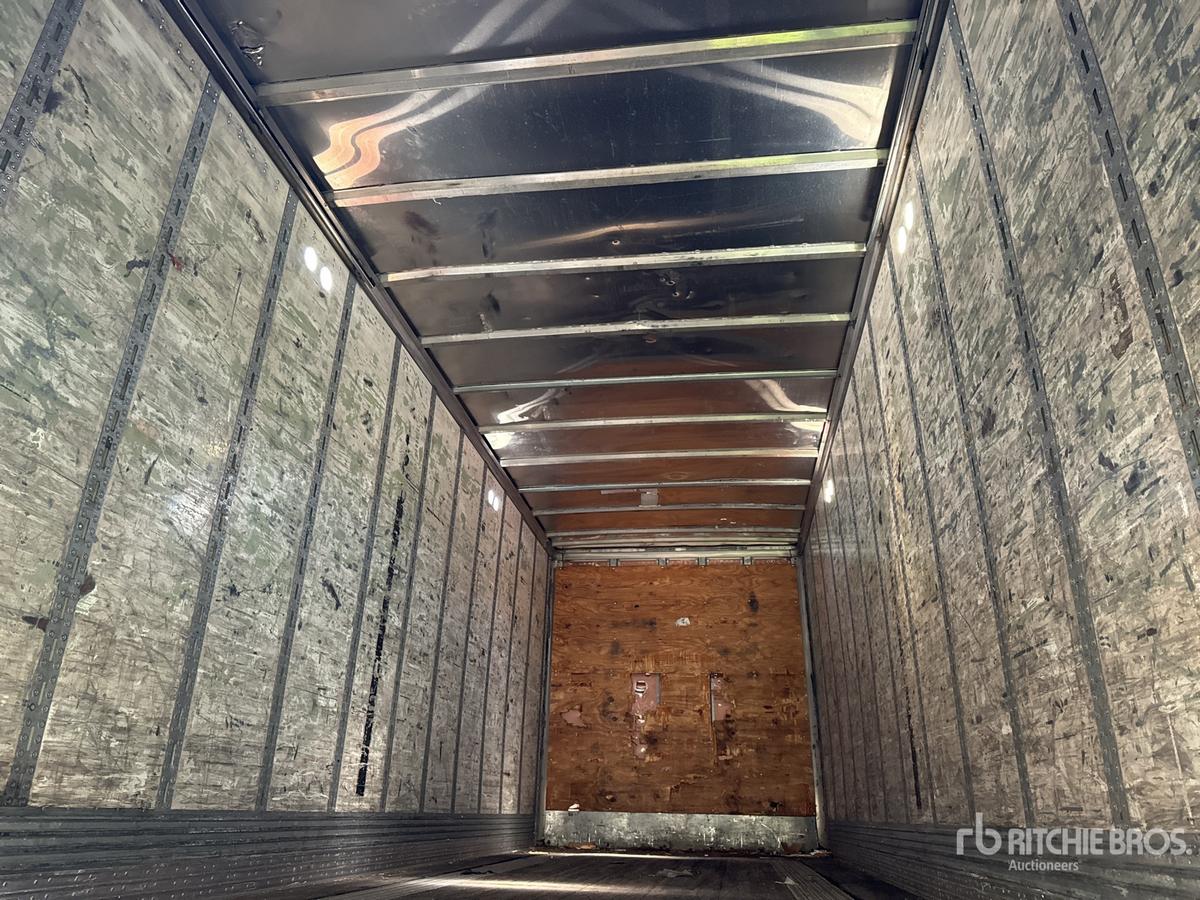 Trailer interior showing metal sidewalls with insulation panels and wooden back wall; cargo space empty.