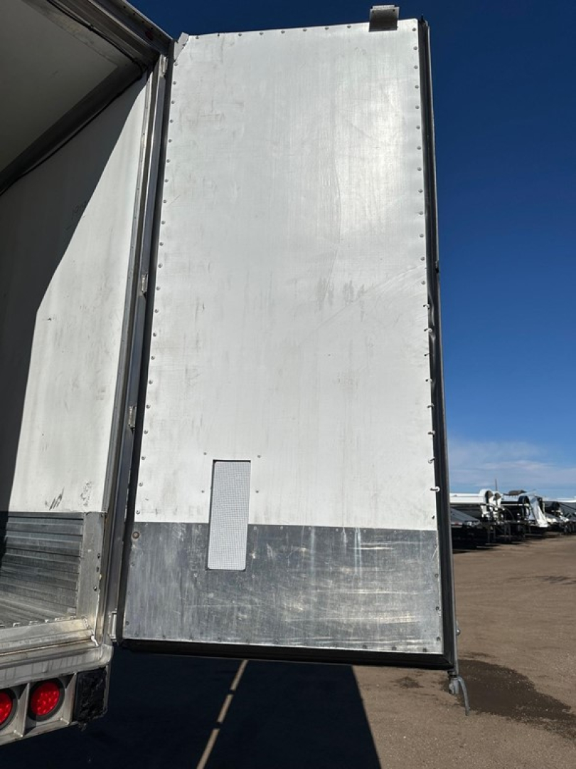 Rear of a 2019 Utility 3000R reefer trailer with tall white door panels and silver lower transition; side door vent and hinge rivets visible.