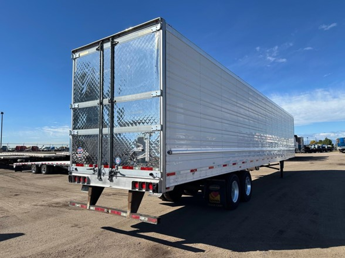 Trailer side and rear view of a 2019 Utility 3000R refrigerated trailer showing aluminum exterior, twin rear doors with diamond plate, undercarriage wheels, and mud flaps.