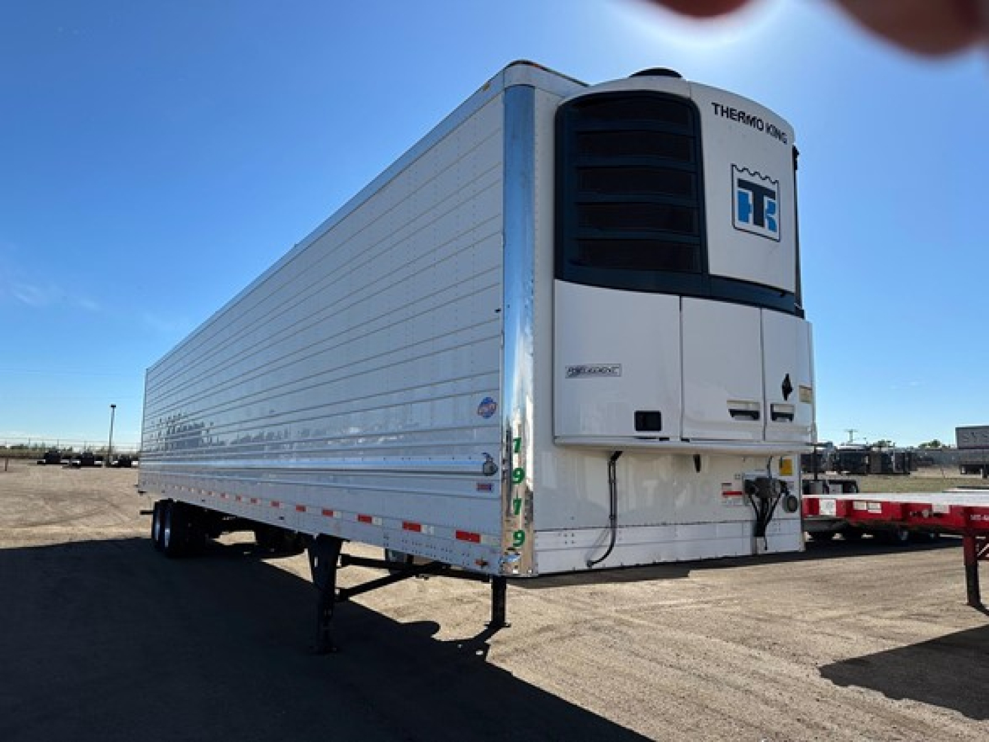 Utility reefer trailer 2019 model with Thermo King unit and white box, side view showing chassis and wheels under clear sky.