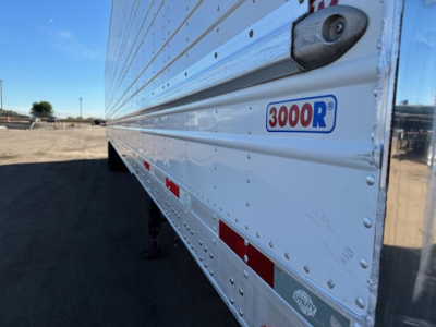 Trailer side showing 3000R logo on Utility 3000R reefer trailer with reflective stripes and riveted aluminum siding.