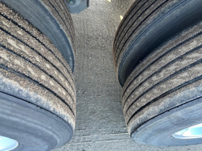 Twin semi-trailer tires on a Utility 3000R reefer trailer showing tread grooves and wheel rims.