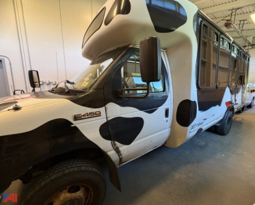 Ford E-450 Transit bus with wheelchair lift in a garage interior, side view showing front cab and passenger area.