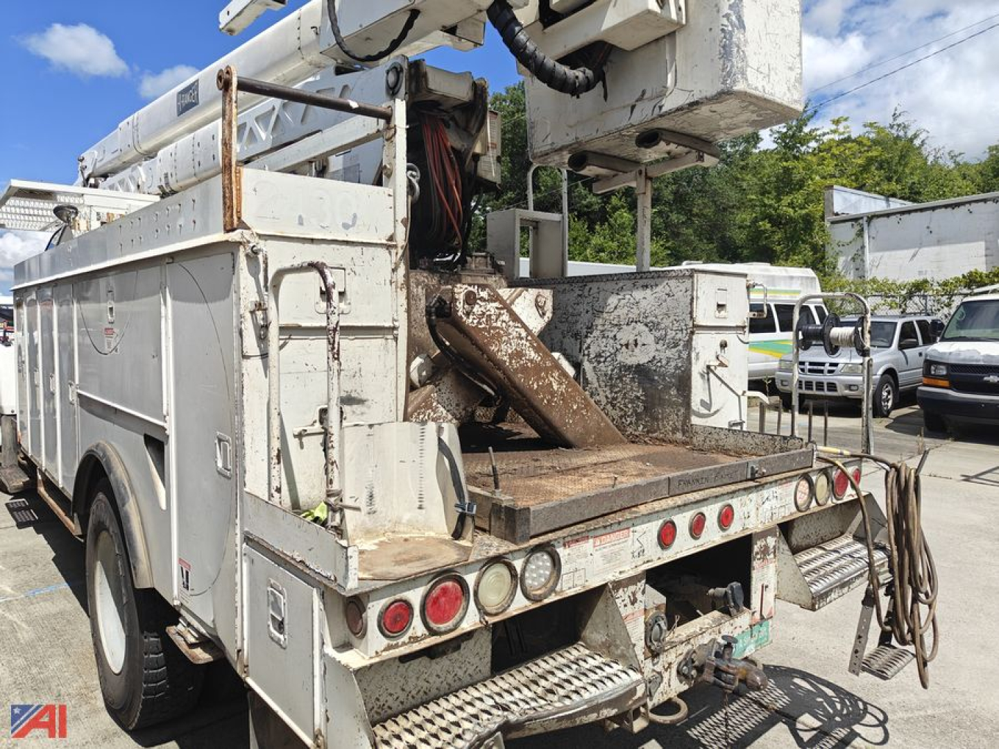 Bucket truck rear view showing hydraulic boom base and platform on a used 2005 GMC Kodiak bucket truck.