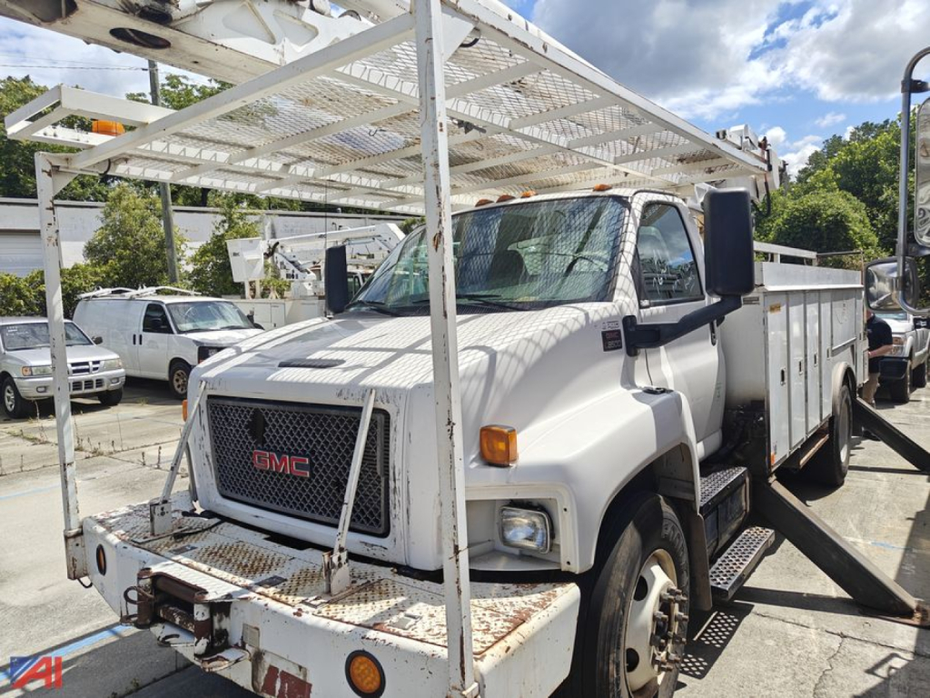 GMC Kodiak bucket truck in-service showing front grille with red GMC logo and rack-over boom platform.
