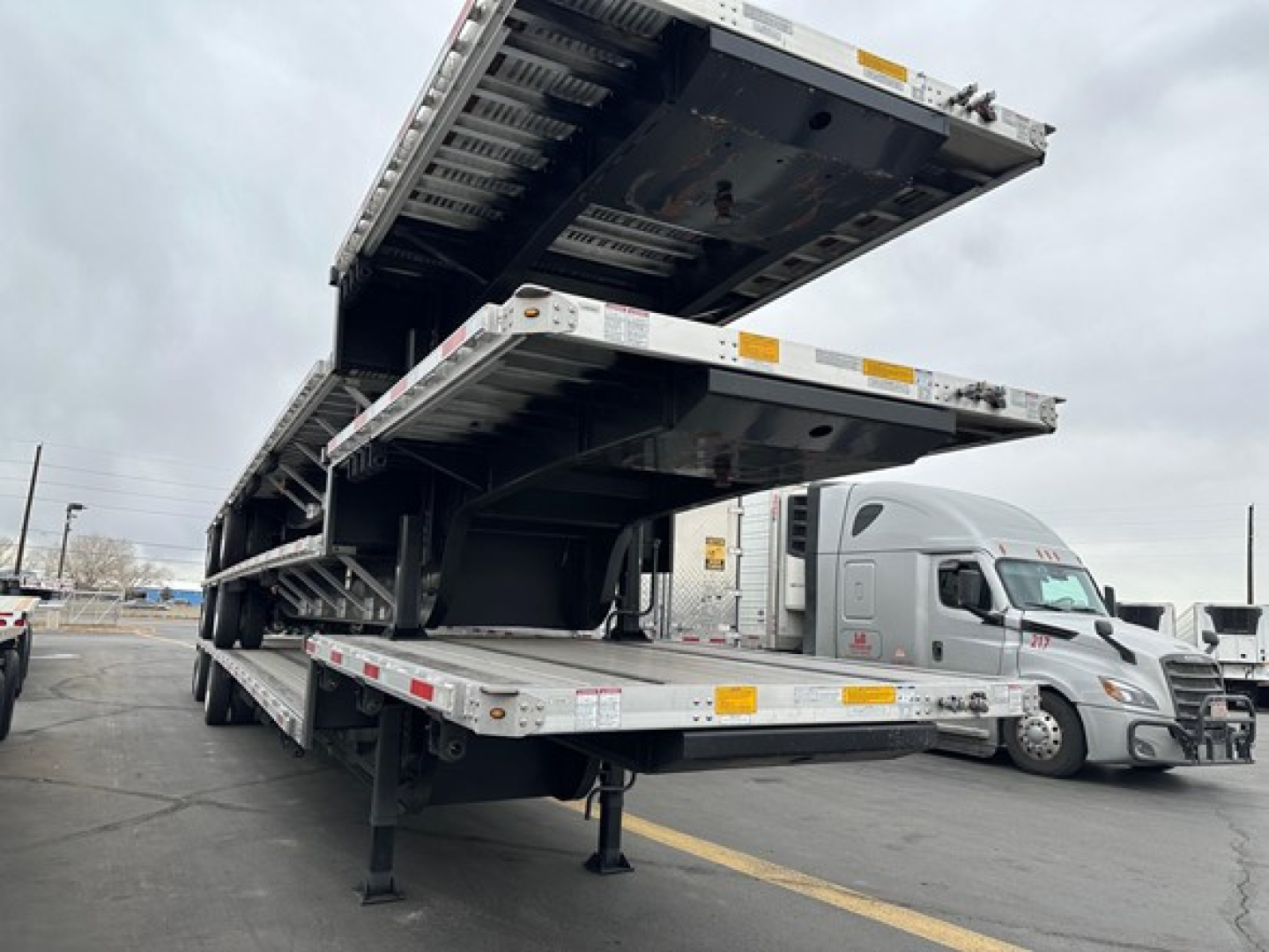 Trailer deck showing multiple drop deck sections of a utility combo drop deck trailer in stacked position.